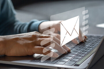 Human hands using laptop typing on keyboard and surfing the internet on office table with email...