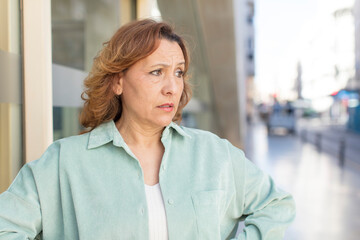 middle age woman feeling sad and stressed, upset because of a bad surprise, with a negative, anxious look