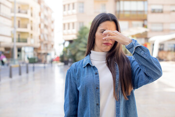 pretty young adult woman feeling disgusted, holding nose to avoid smelling a foul and unpleasant stench - obrazy, fototapety, plakaty
