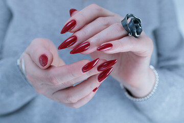 Woman hand with long nails and a dark red bordeaux nail polish 