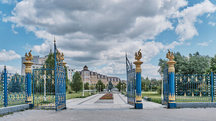 Open front gates to Millennium Park, decorated with golden figurines of zilants, Kazan, Russia
