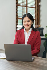 Portrait of beautiful smiling young businesswoman sitting at bright in office modern work and typing on laptop