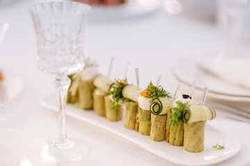Сold appetizer of pancakes with cream cheese and caviar.