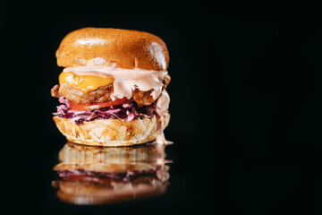 Burger with crispy chicken fillet on a black background