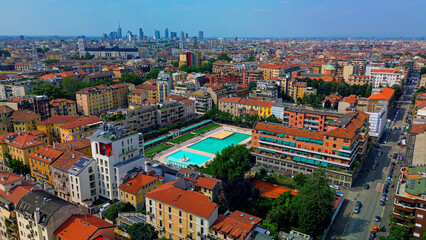 Fototapeta na wymiar Bagni Misteriosi Aerial view of the city peysache and rooftops. New urban swimming pool with clear blue water. Luxurious relaxation by the water. Skyline in skyscrapers. Milan Italy 07.2023
