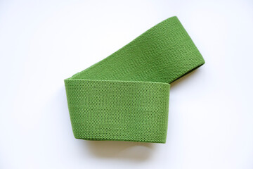 Fototapeta premium Sports equipment. Green elastic band for fitness.