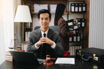 Asian lawyer man working with a laptop and tablet in a law office. Legal and legal service concept. Looking at camera in modern office.