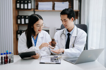Medical technology network team meeting concept. Asian Doctor hand working with smart phone modern digital tablet and laptop computer with graphics chart interface,