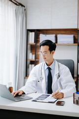 Medical technology concept. Asian Doctor working with mobile phone and stethoscope in modern office