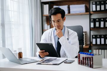 Medical technology concept. Asian Doctor working with mobile phone and stethoscope in modern office