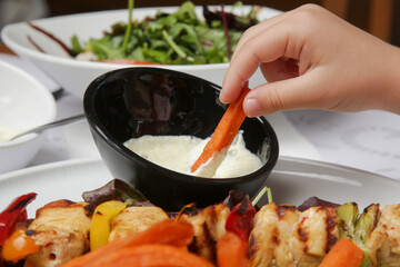 Greek souvlaki, sweet potatoe and tzatziki yogurt dip served on the plate in the restaurant