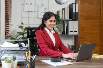 Portrait of beautiful smiling young businesswoman sitting at bright in office modern work and typing on laptop