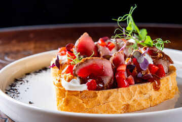 Strawberry bruschetta with duck meat, goat cheese on plate