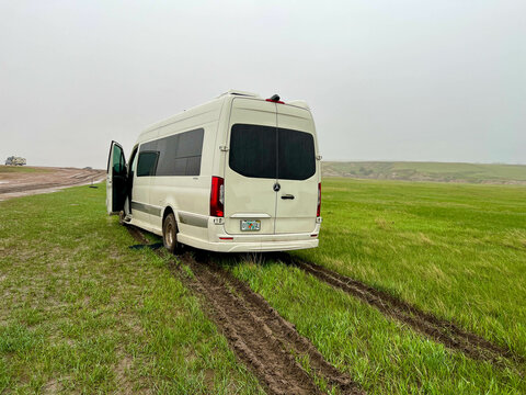 A RV Sprinter Van stuck in the mud in the Wall, SD boondocking spot in Badlands National Park.