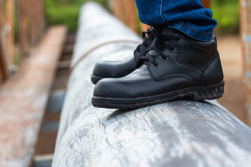 Wear safety shoes to ensure safety at work. construction workers wear safety shoes. People with...