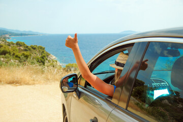 A happy girl from car at sea greece background