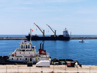 Puerto con las grúas de carga al fondo y delante el practico del puerto