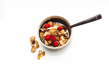Muesli with raspberries and milk in a bowl on a white background. Healthy breakfasts, proper nutrition