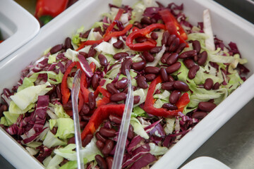 Various fresh salads served on a buffet line, healthy meal option