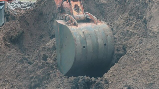 auto excavator with rotary bucket and telescopic boom digs a hole to replace the pipeline, industry
