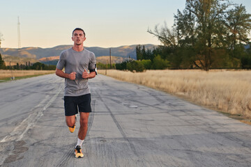 A young handsome man running in the early morning hours, driven by his commitment to health and...