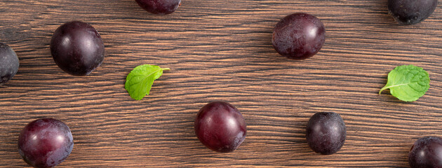 Delicious bunch of grapes fruit spilled over wooden table background.