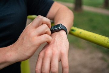 Obraz na płótnie Canvas Close-up of man hand with smartwatch during outdoors workout, health and sport tracking 