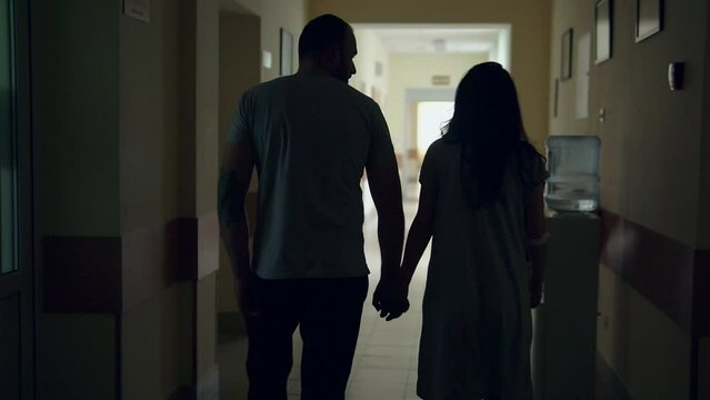 Couple walking in corridor of hospital during labor