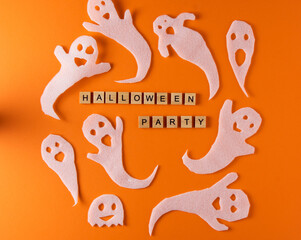 White ghosts craft for Halloween party. Wrapping paper ghost on orange background top view. Cartoon creepy Whisper. DIY hand made. Set boo characters. Word wooden letter phrase.