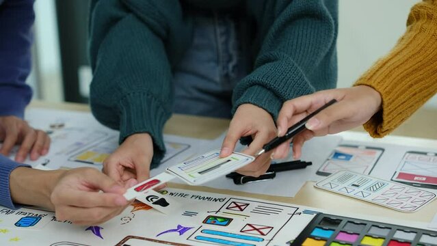 Designer team working on new website wireframe, planning application development for web mobile phone at meeting