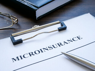 Clipboard with microinsurance application and a notepad.