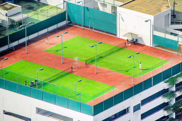 Tennis players competing on a stunning rooftop court, showcasing their skills against a panoramic...