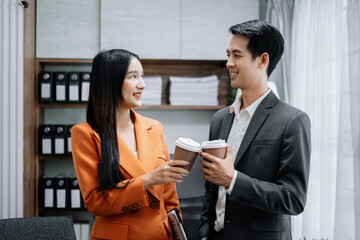colleagues clinking cups of coffee in office.