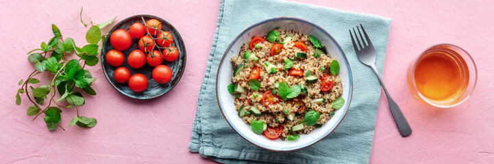 Quinoa tabbouleh salad in a bowl panorama, a healthy dinner with tomatoes and mint, overhead flat...