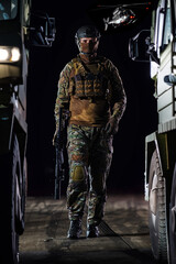 Fototapeta na wymiar A soldier marching through the dark of night, accompanied by two military trucks, as he embarks on a perilous military mission, embodying the unwavering determination, teamwork, and preparedness