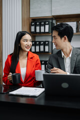 colleague Asian descent holds a cup of coffee and smiles happily.