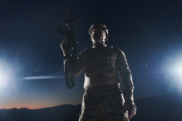 A professional soldier in full military gear striding through the dark night as he embarks on a perilous military mission