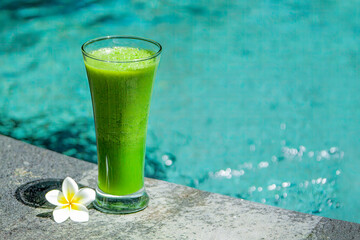 Green cocktail by the pool: A refreshing and vibrant beverage, garnished with fresh herbs, served poolside for a perfect summer indulgence