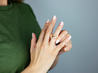 Divorce concept.A young woman removes a wedding ring from her finger.