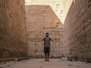 A young tourist visiting the beautiful temple of Edfu in the city of Edfu, Egypt. On the bank of...
