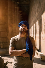 A young tourist in a blue turban visiting the Edfu Temple in the morning near Aswan city. Egypt,...