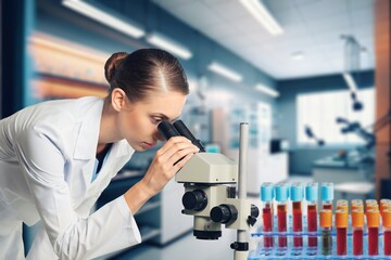 Professional scientist working in modern laboratory, looking in a microscope