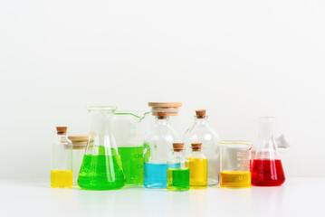 some test tube on the white table with beakers, flasks, and test tubes filled with colorful liquids