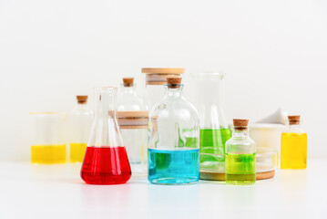 some test tube on the white table with beakers, flasks, and test tubes filled with colorful liquids