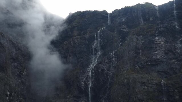 Impressive waterfall in Norway. Clouds and fog moving in front of the steep cliffs