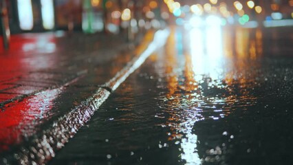 Feet walk through puddles on a rainy evening on a city street