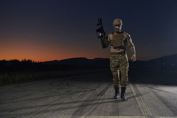 A professional soldier in full military gear striding through the dark night as he embarks on a...