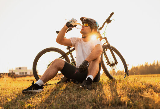 A professional mountain bike cyclist drinking water from the bottle active healthy lifestyle.