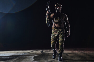 A professional soldier in full military gear striding through the dark night as he embarks on a perilous military mission