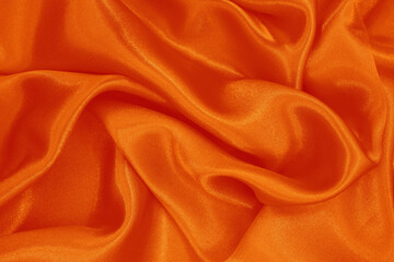 Orange fabric texture background, detail of silk or linen pattern.